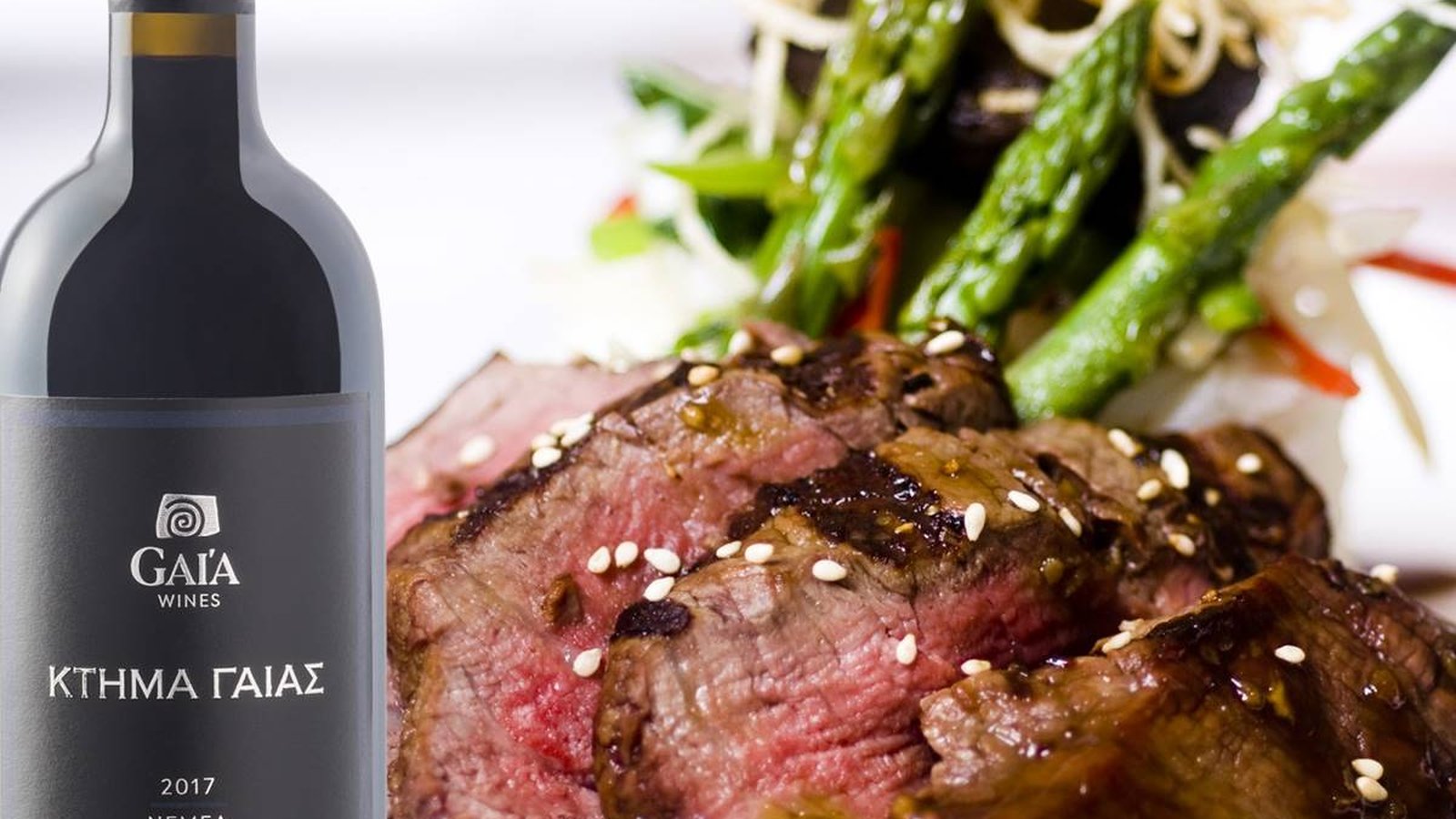 A bottle of Gaia Estate, the oak-aged Agiorgitiko from PDO Nemea, beside sliced medium-rare steak